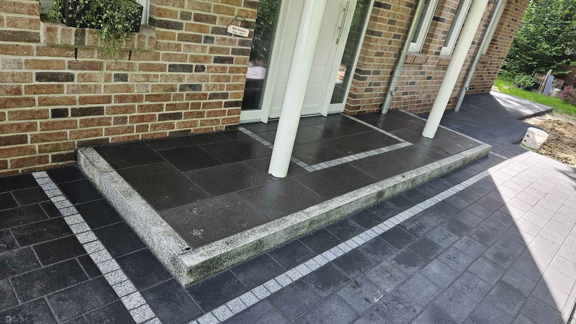 Ein Backsteingebäude mit einem schwarz-weißen Backsteinweg davor.