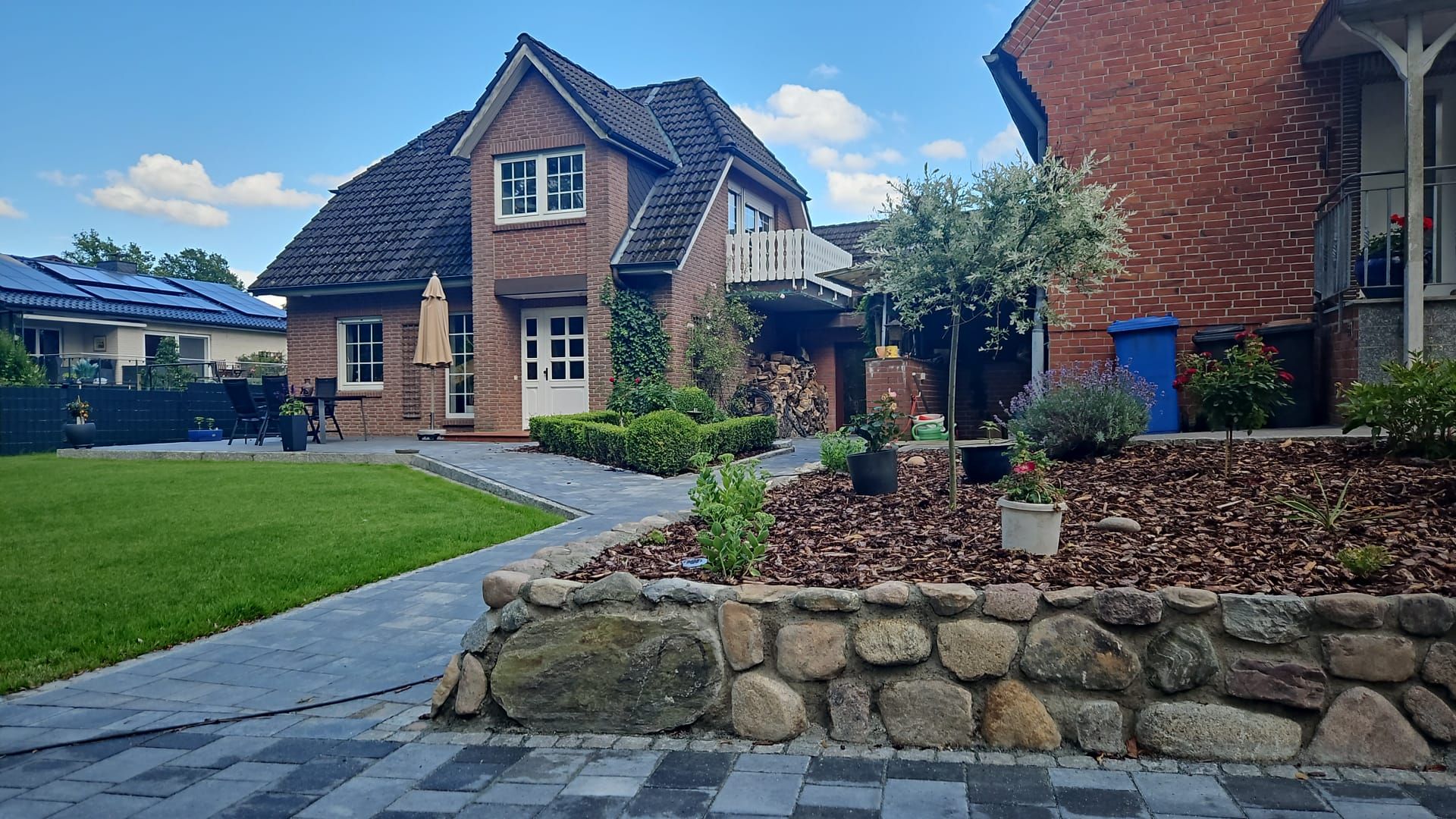 Ein großes Backsteinhaus mit einer Steinmauer davor