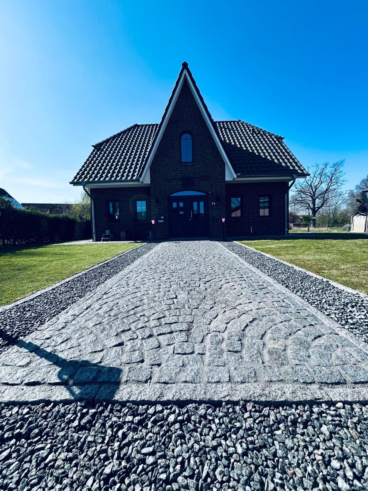 Ein Haus mit einer gepflasterten Auffahrt, die dorthin führt