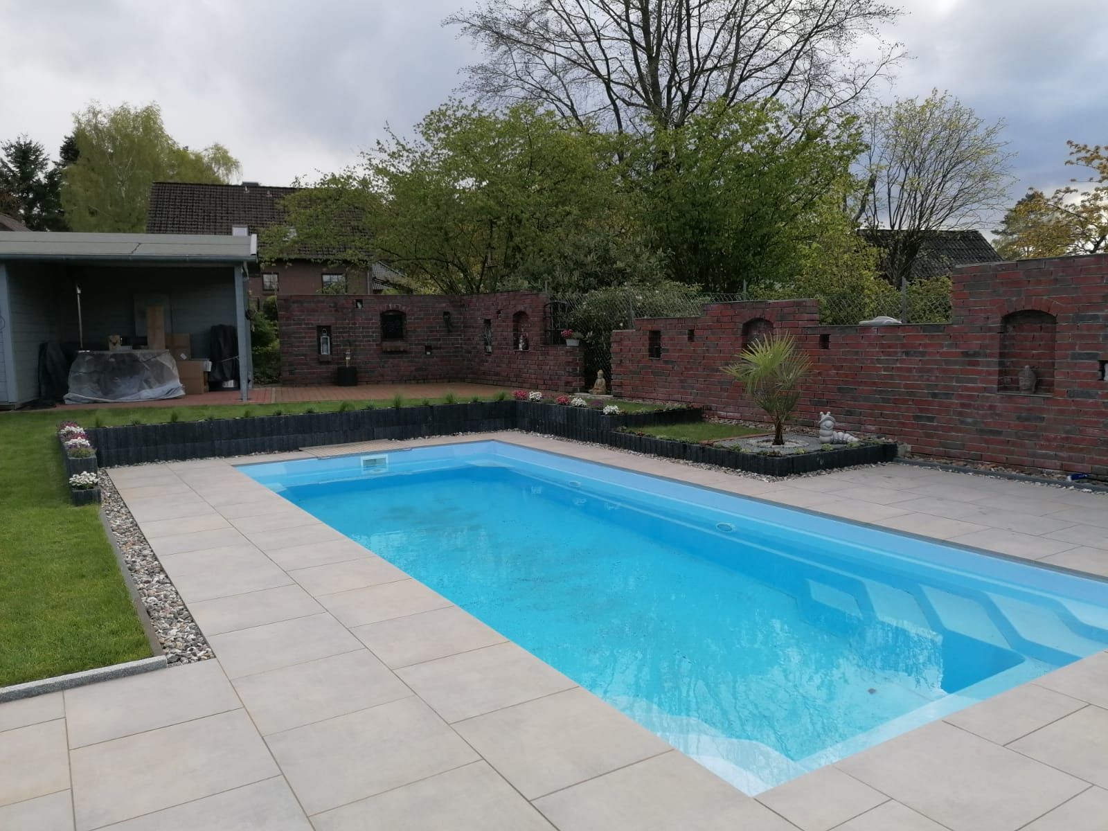 Im Hinterhof eines Hauses befindet sich ein großer Swimmingpool.