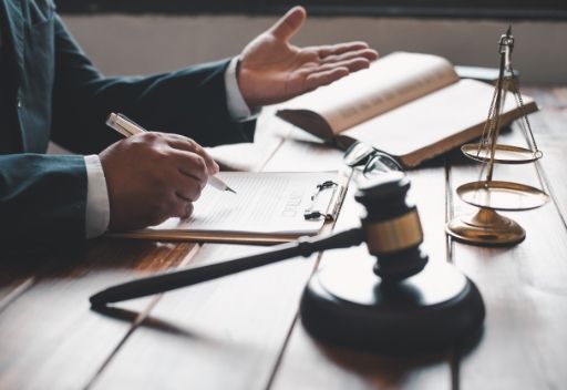 Un juez está sentado en una mesa con un mazo y una balanza de justicia.