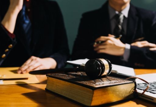 El mazo de un juez está encima de un libro sobre una mesa.