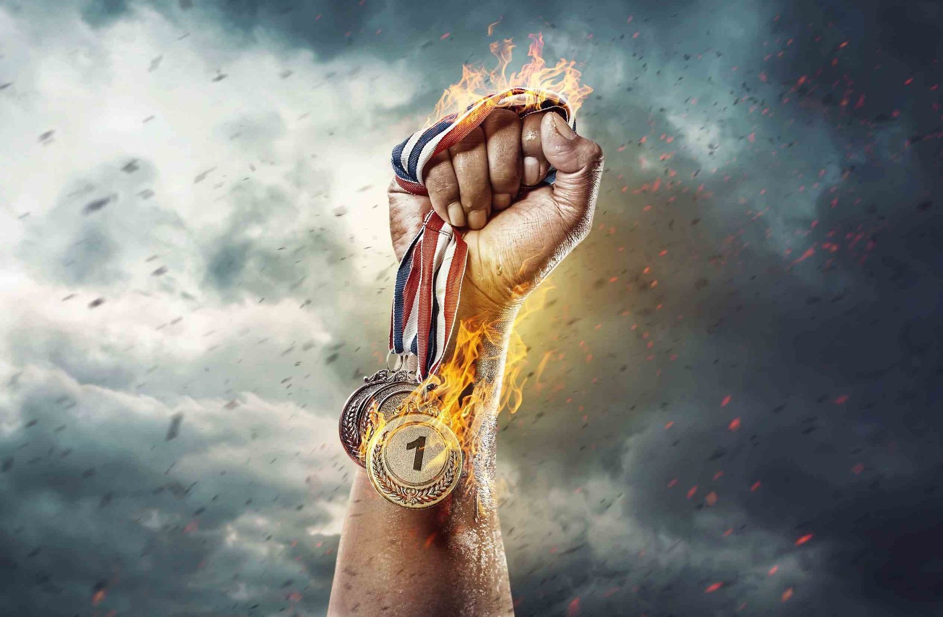 Una persona sostiene una medalla de oro en su puño.