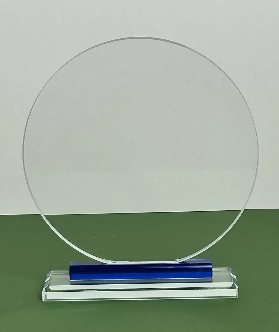 Una placa de vidrio transparente con una base azul está sobre una mesa verde.