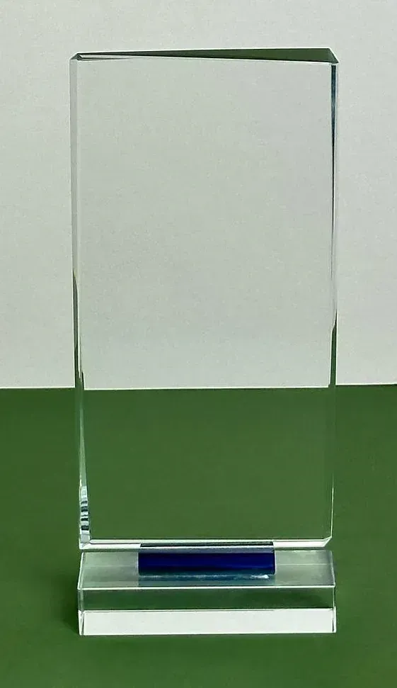 Una placa de vidrio transparente con una base azul está sobre una mesa verde.