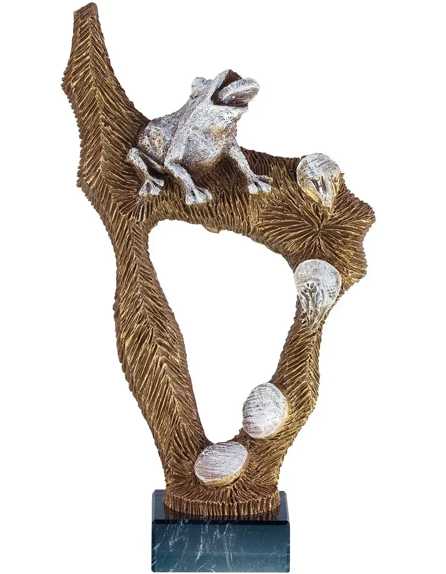 Una estatua de una rana sentada en una rama con pelotas de golf.