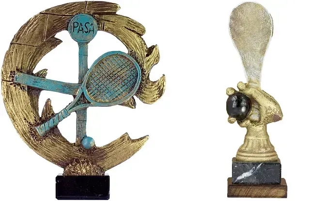 Un trofeo con una raqueta de tenis y una mano sosteniendo una pelota de tenis