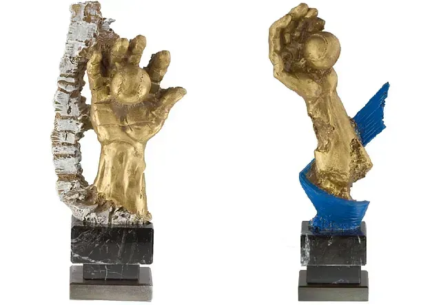 Una estatua de oro y plata de una mano sosteniendo una pelota.