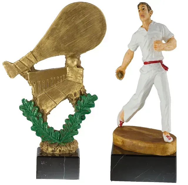 Una estatua de un hombre sosteniendo una raqueta de tenis junto a una estatua de un hombre corriendo.