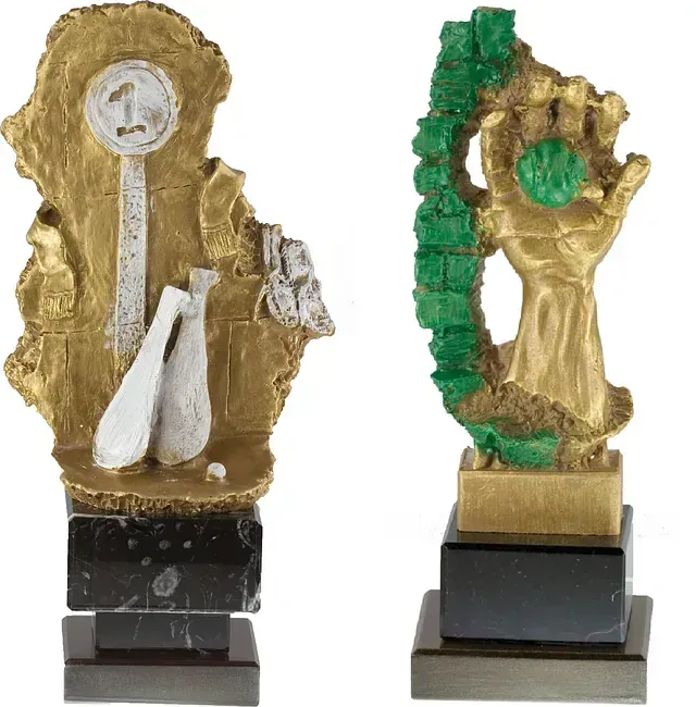 Una estatua dorada de una mano sosteniendo un objeto verde.