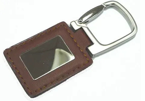 Un llavero de cuero marrón con un mosquetón de metal sobre un fondo blanco.