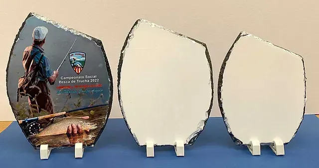 Tres placas con la imagen de un hombre pescando están sobre una mesa.