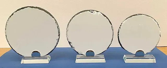 Tres placas de vidrio redondas se encuentran sobre una superficie azul.