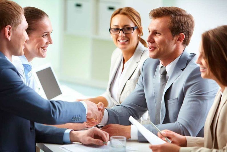 Un grupo de hombres de negocios se dan la mano en una mesa.