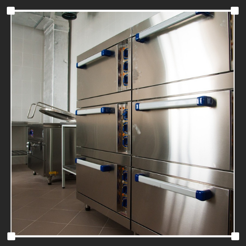 Una hilera de hornos de acero inoxidable con asas azules.