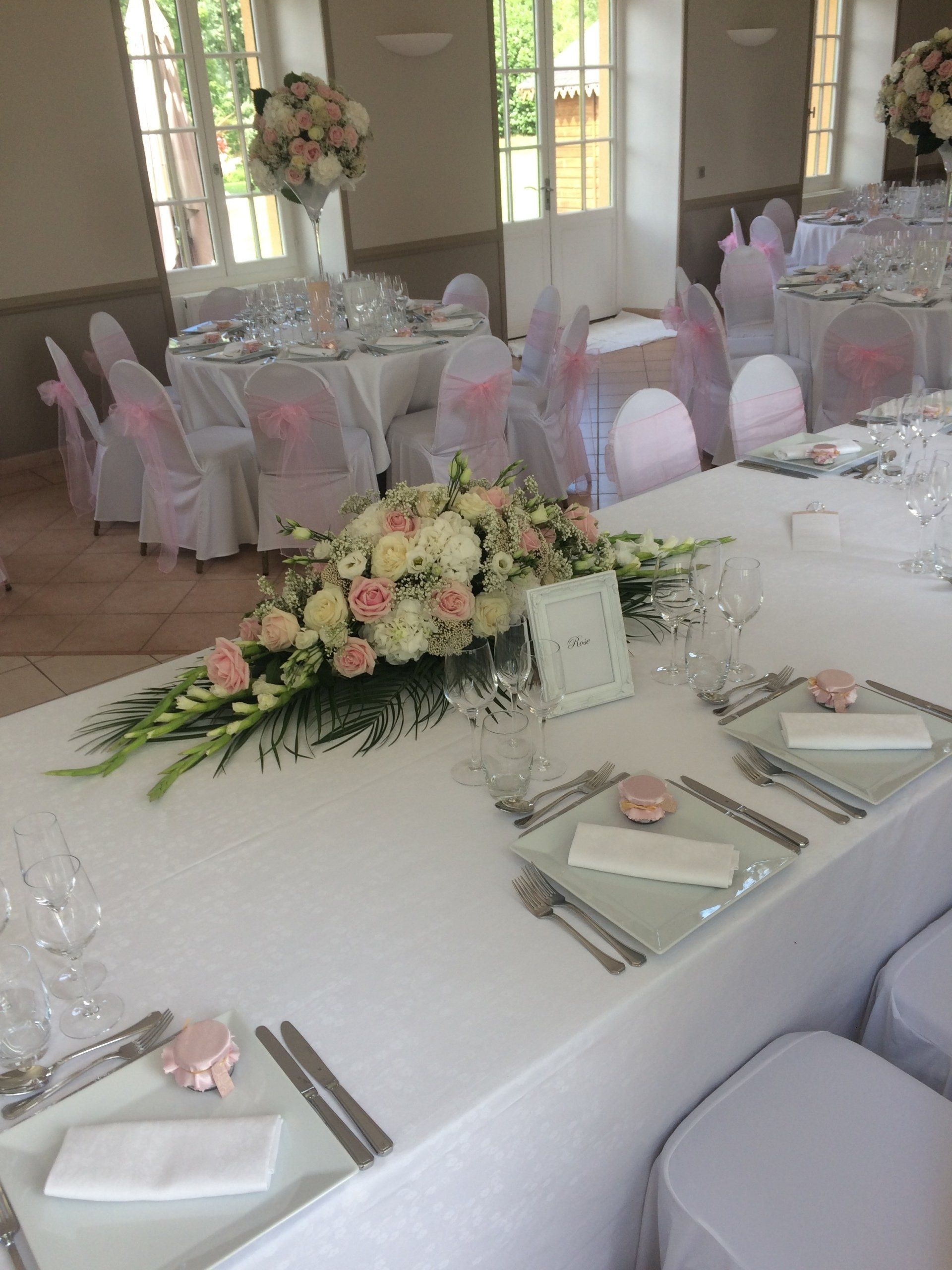 Décoration de table de réception avec une composition florale blanche et rose 