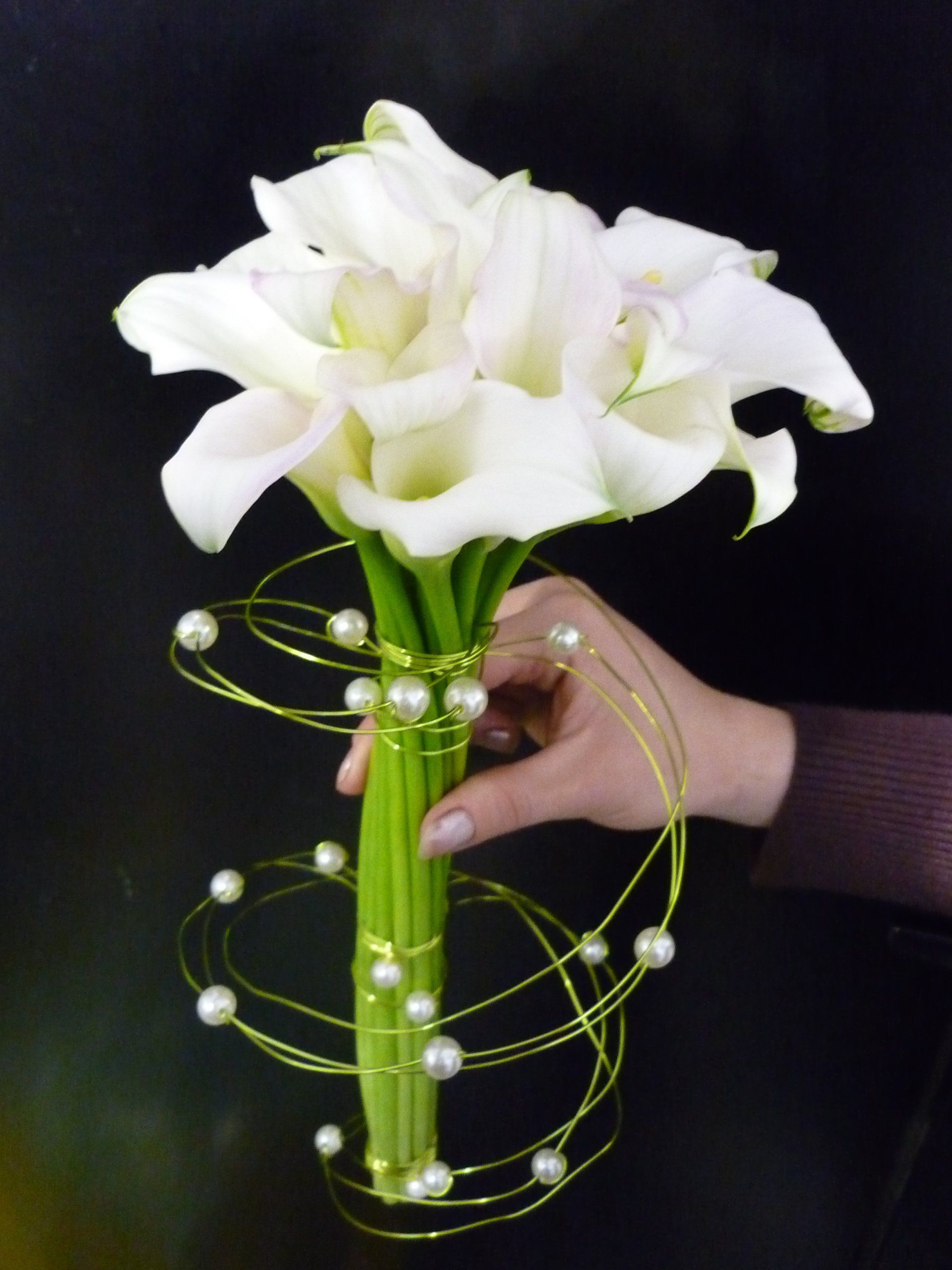 Fleurs blanches en bouquet et tenu par une main