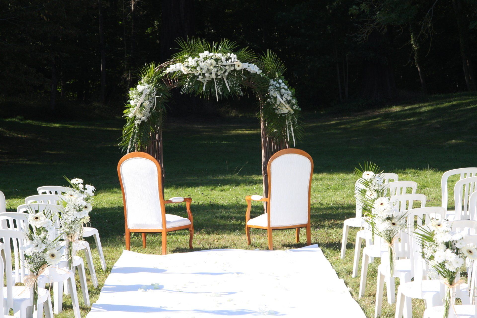 Arche florale de mariage en plein air avec deux fauteuils et l'allée de cérémonie