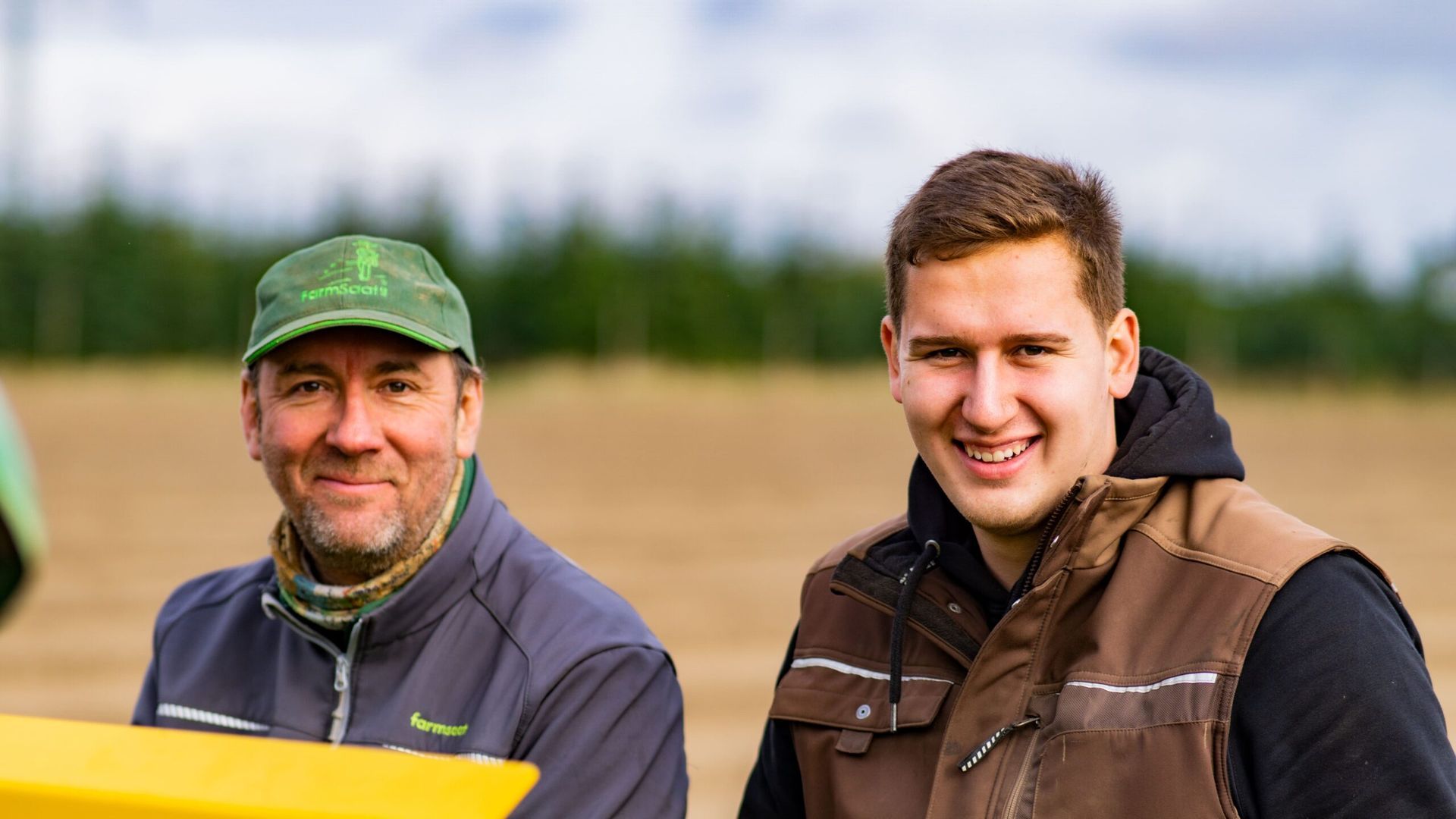 Zwei Männer stehen nebeneinander auf einem Feld.