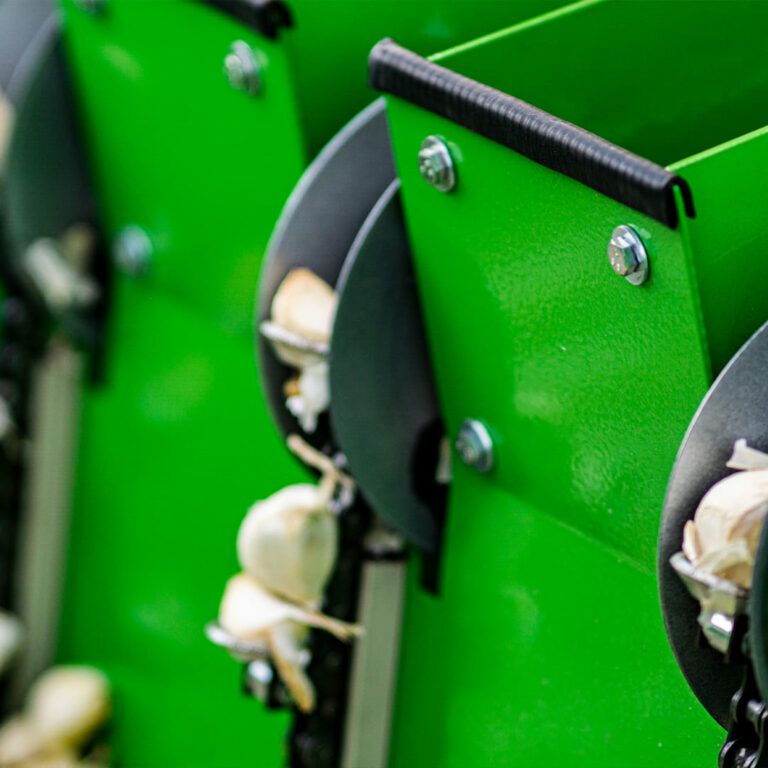 Eine Nahaufnahme einer grünen Maschine mit Knoblauch darin.