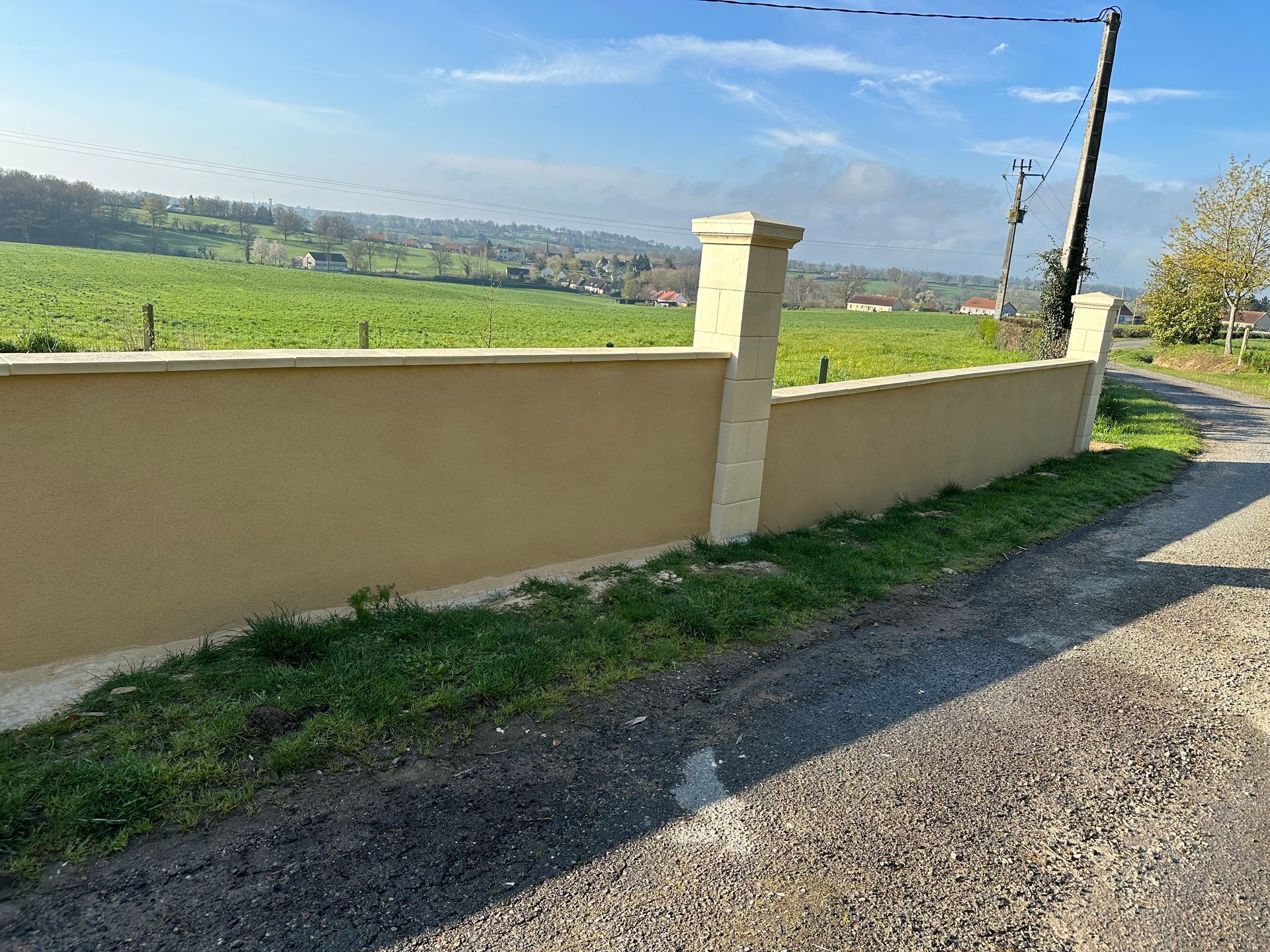 Mur de clôture avec crépi sur le mur et peinture sur les poteaux