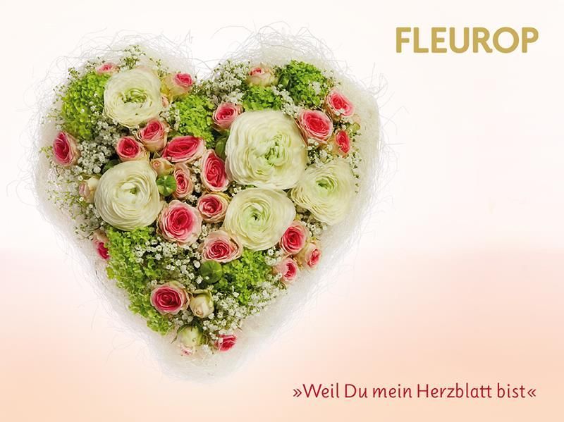 Ein herzförmiger Blumenstrauß auf rosa Hintergrund.