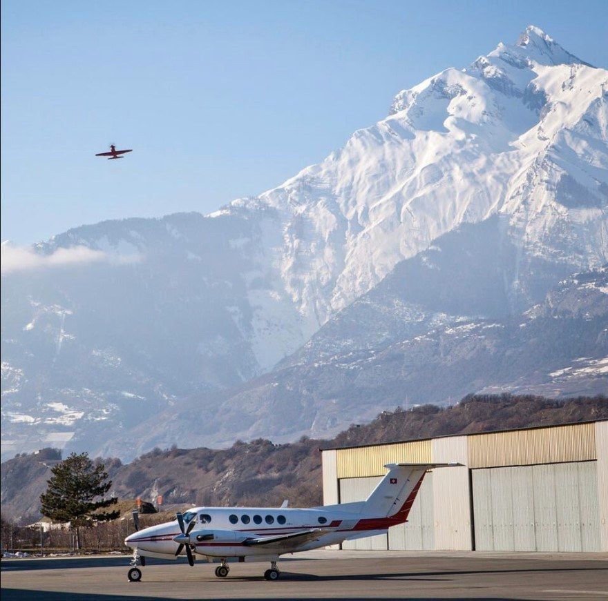 Un petit avion est garé devant une montagne