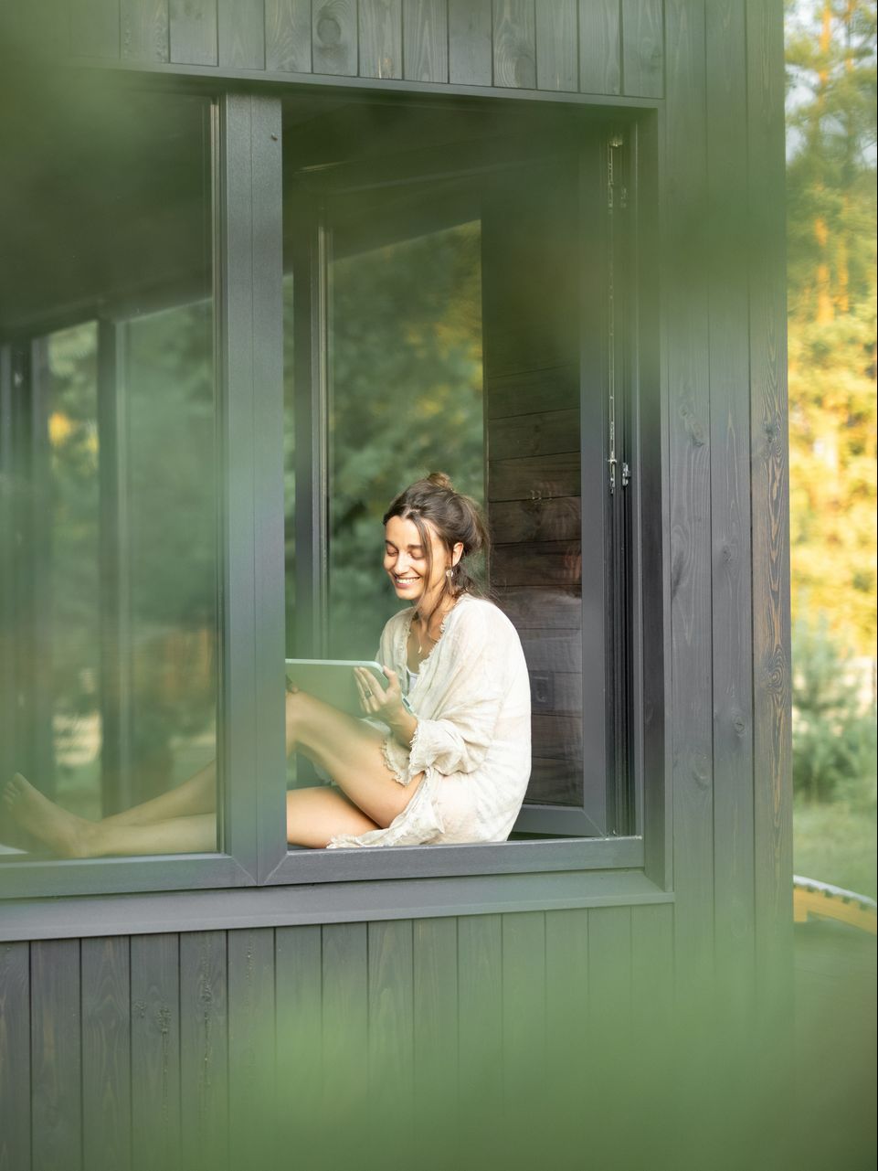 Jeune femme devant une porte-fenêtre