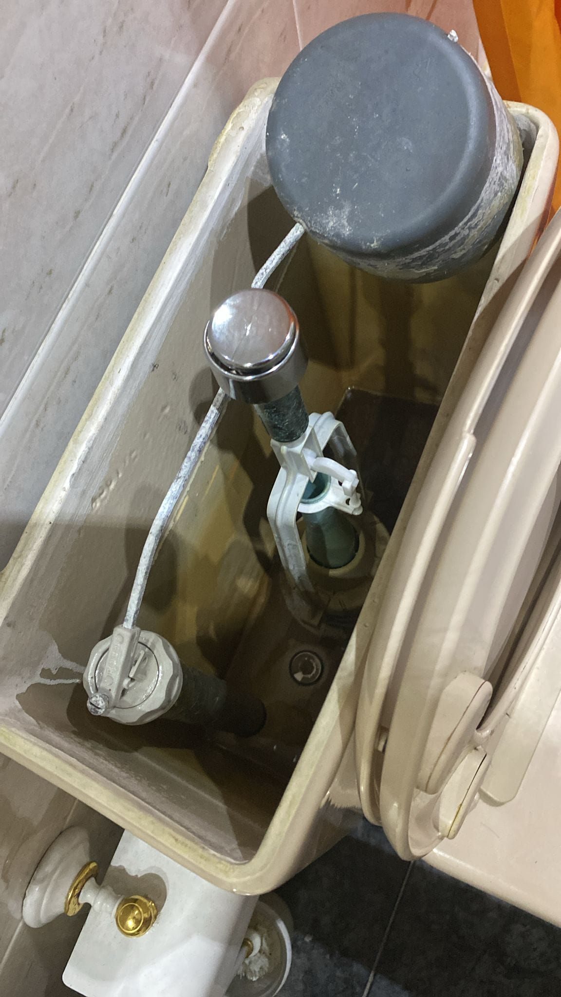 Un primer plano de un tanque de inodoro con agua saliendo de él.