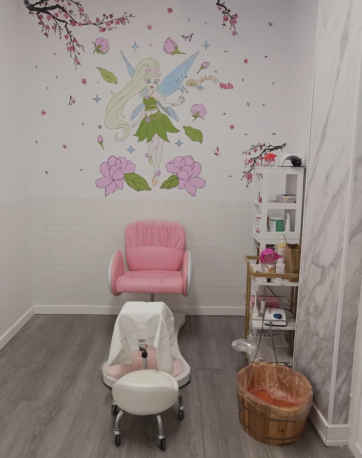 Una habitación con una silla rosa y un hada en la pared.