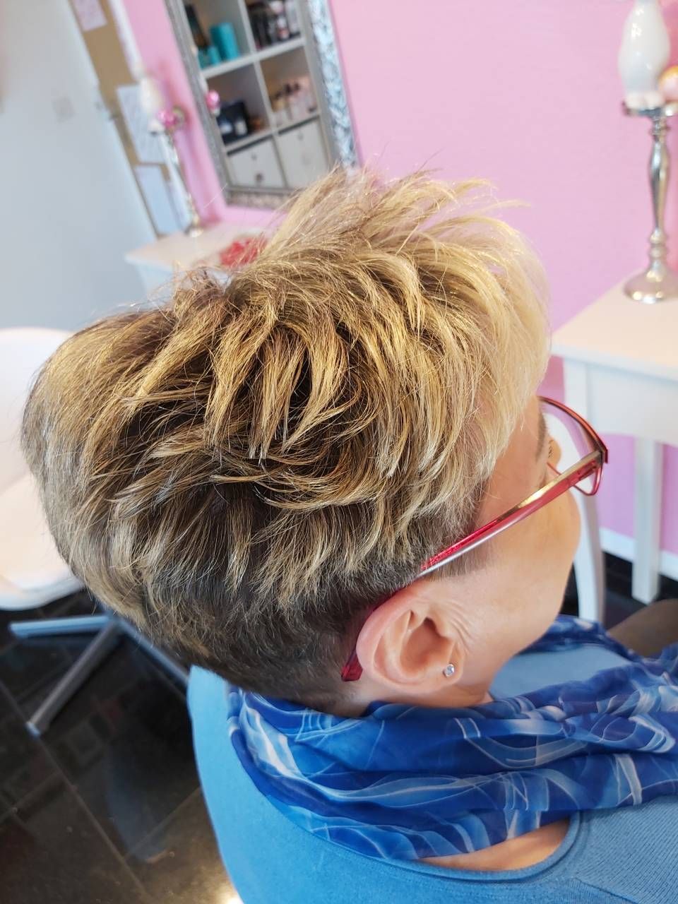 Eine Frau mit Brille und Kopftuch sitzt auf einem Stuhl, BM Hair and Beauty