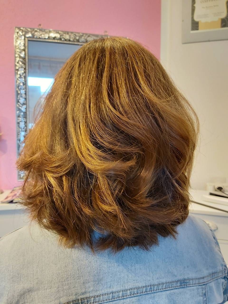 Die Rückseite des Haares einer Frau wird vor einem Spiegel gezeigt. BM Hair and Beauty