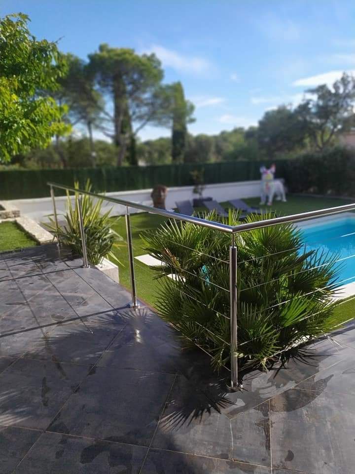 Garde-corps le long d'une terrasse autour d'un jardin avec piscine