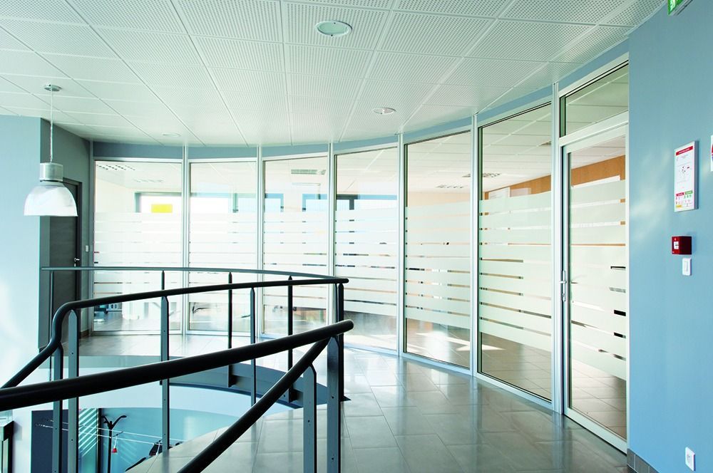 Grande séparation de vitres de forme circulaire au pied d'une cage d'escalier