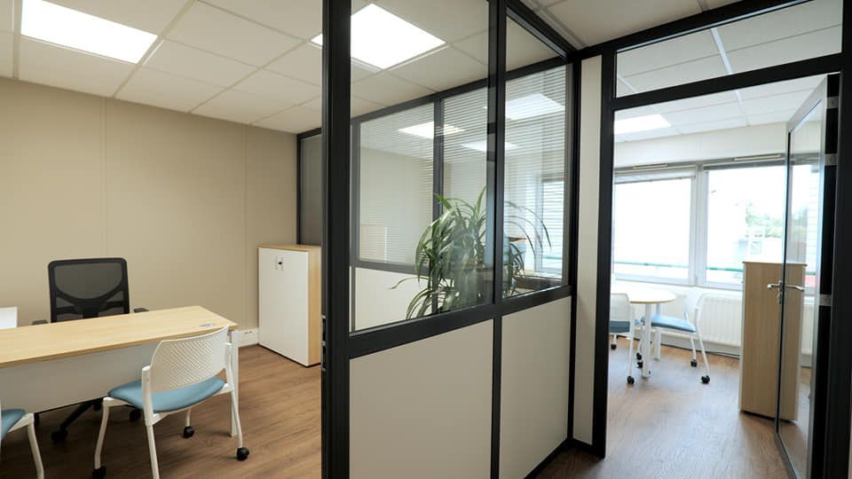 Pièce de bureau avec une grande vitre fixée sur la cloison 