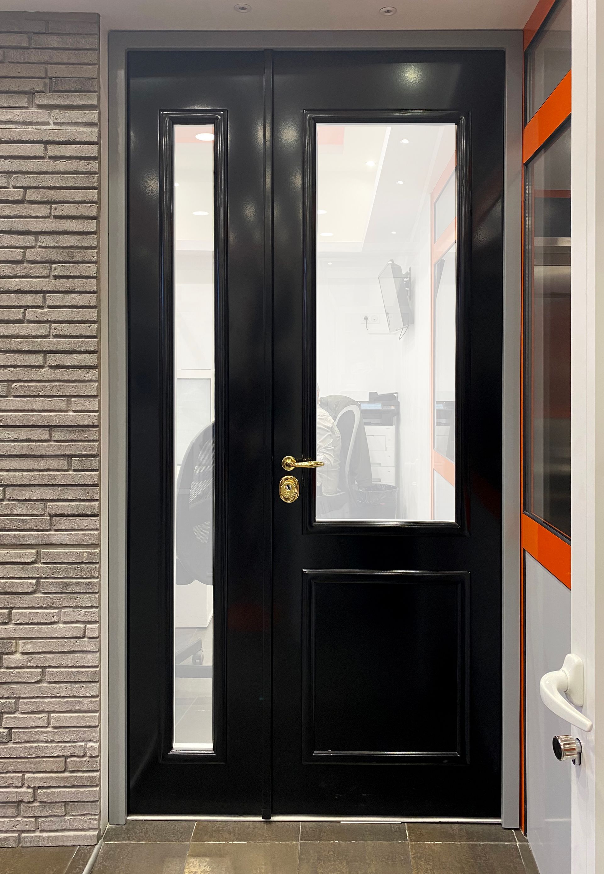 Exposition d'une porte d'entrée blindée noir à la poignée dorée