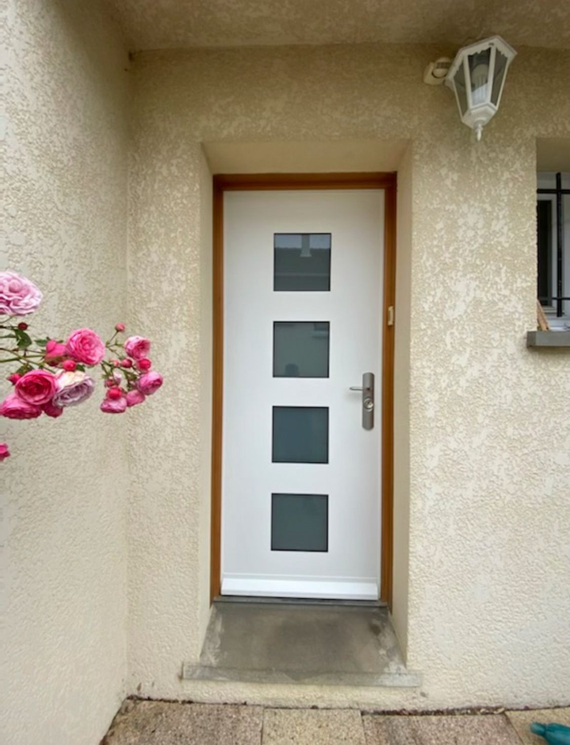 Porte blindée blanche comportant quatre petite vitres