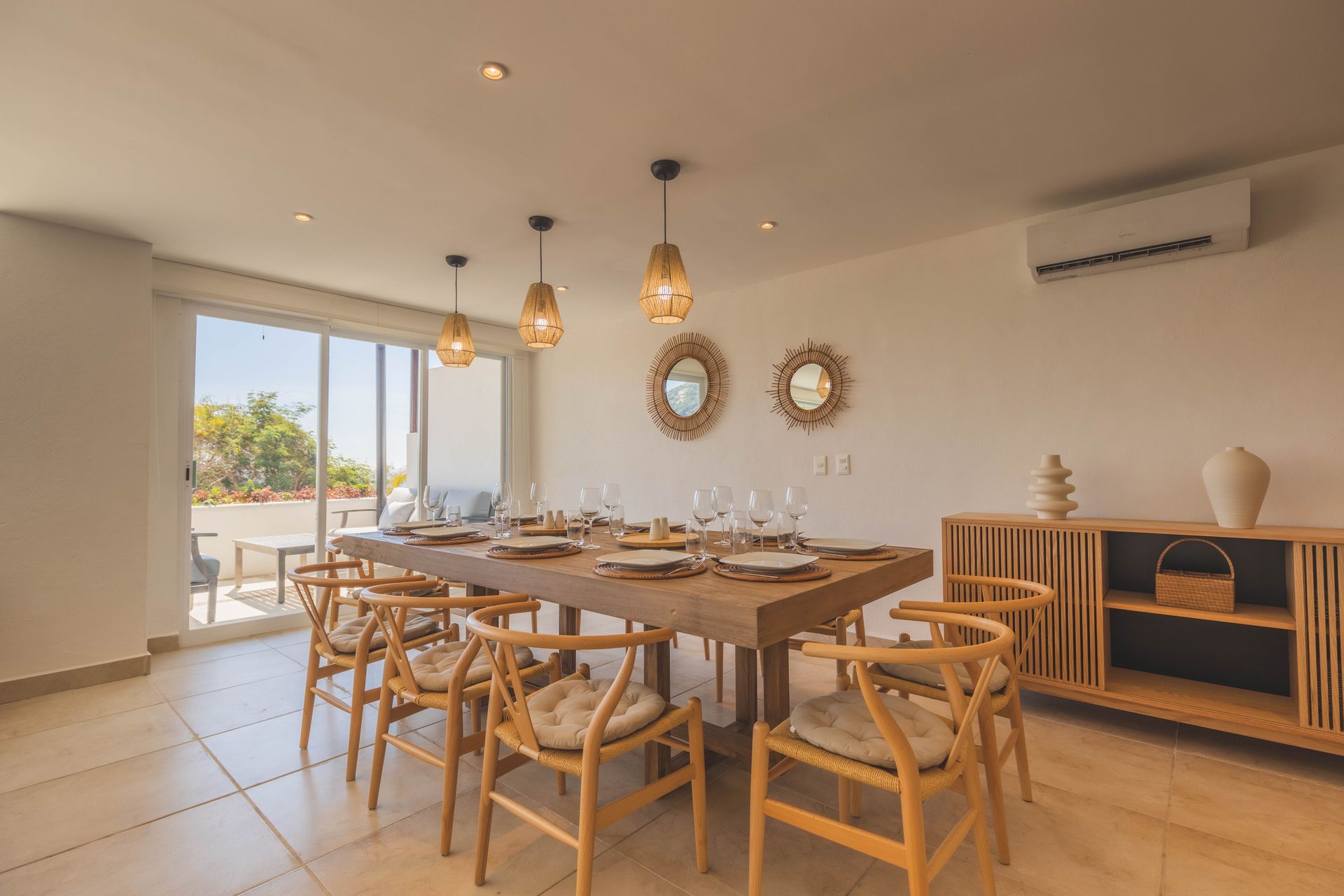 A dining room with a long wooden table and chairs.