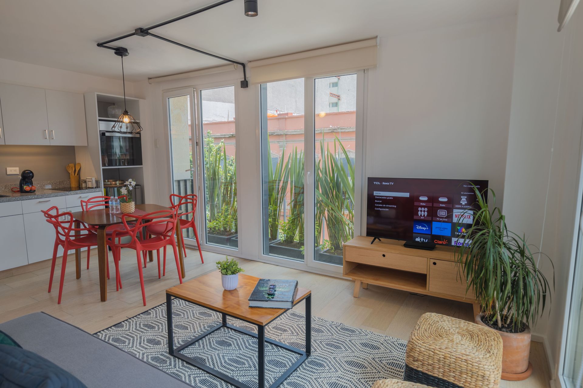 A living room with a table , chairs , and a television.