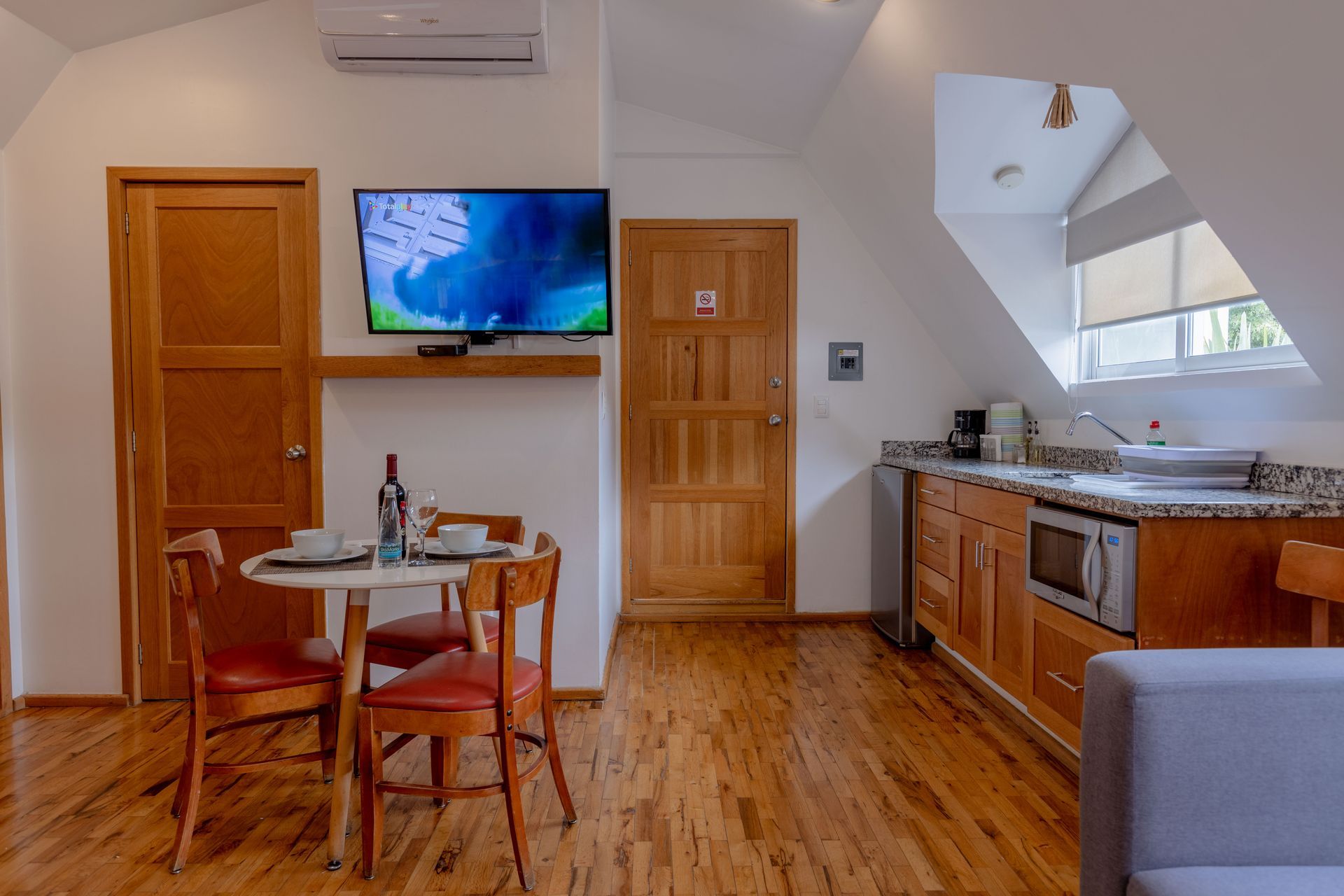 A kitchen with a table and chairs and a flat screen tv.