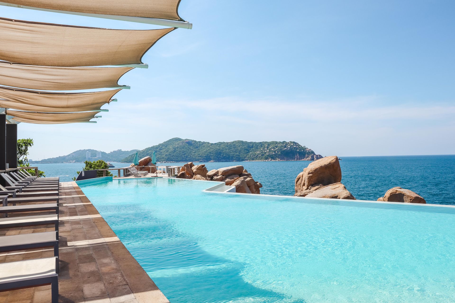 An infinity pool with a view of the ocean and mountains