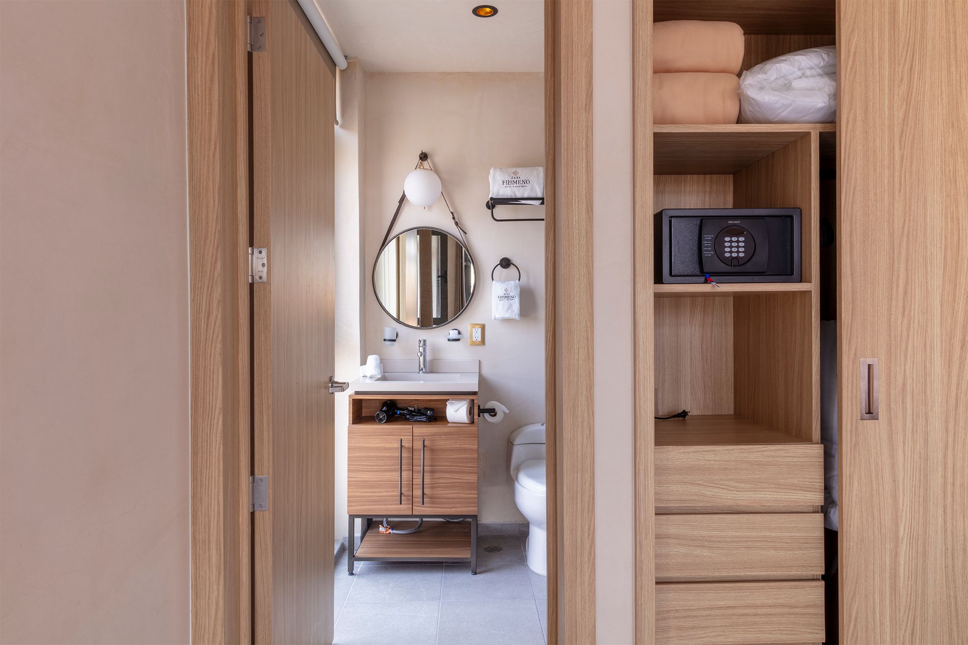 A bathroom with a sink , toilet , mirror and closet.