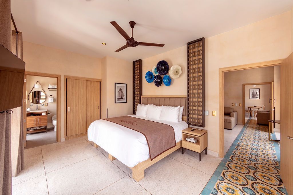 A bedroom with a large bed and a ceiling fan
