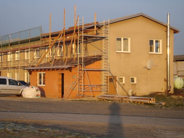 Baufortschritt am Firmengebäude mit Holzgerüst und teilweiser Klinkerfassade.