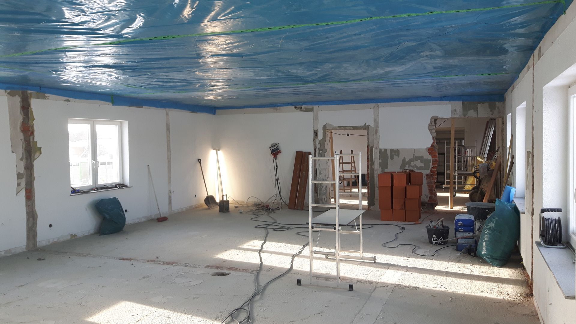 Innenraum während der Abrissarbeiten mit blauer Schutzfolie an der Decke.