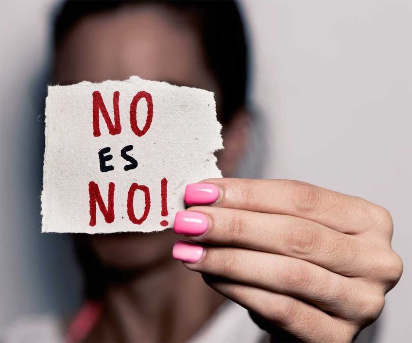 Una mujer sostiene un trozo de papel que dice no es no