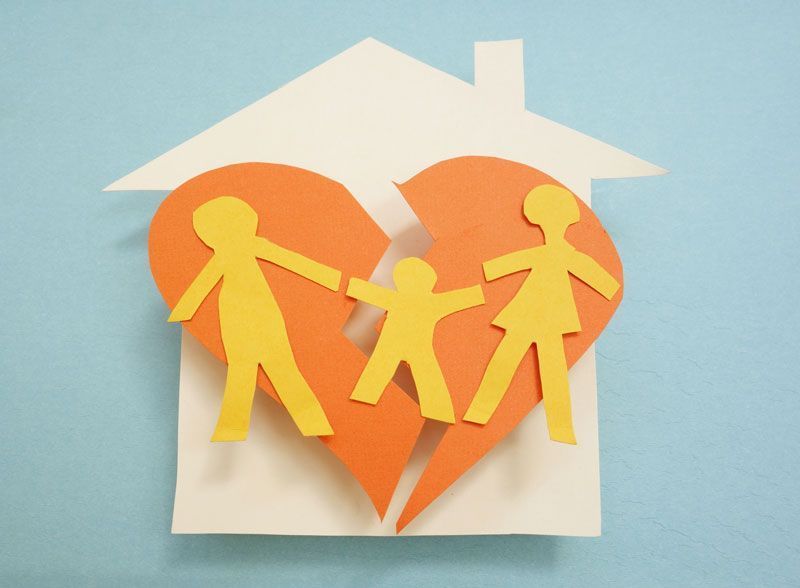 Un recorte de papel de una casa con un corazón roto en el medio.