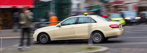 Eine Person im Rollstuhl sitzt in einem silbernen, barrierefreien Transporter mit geöffneter Schiebetür.