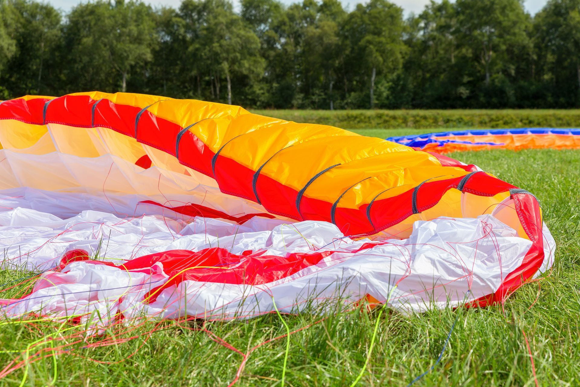 Un homme et un enfant portant des casques rouges pilotent un parachute