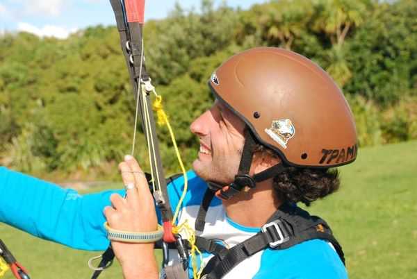 Un homme portant un casque marron tient un parachute